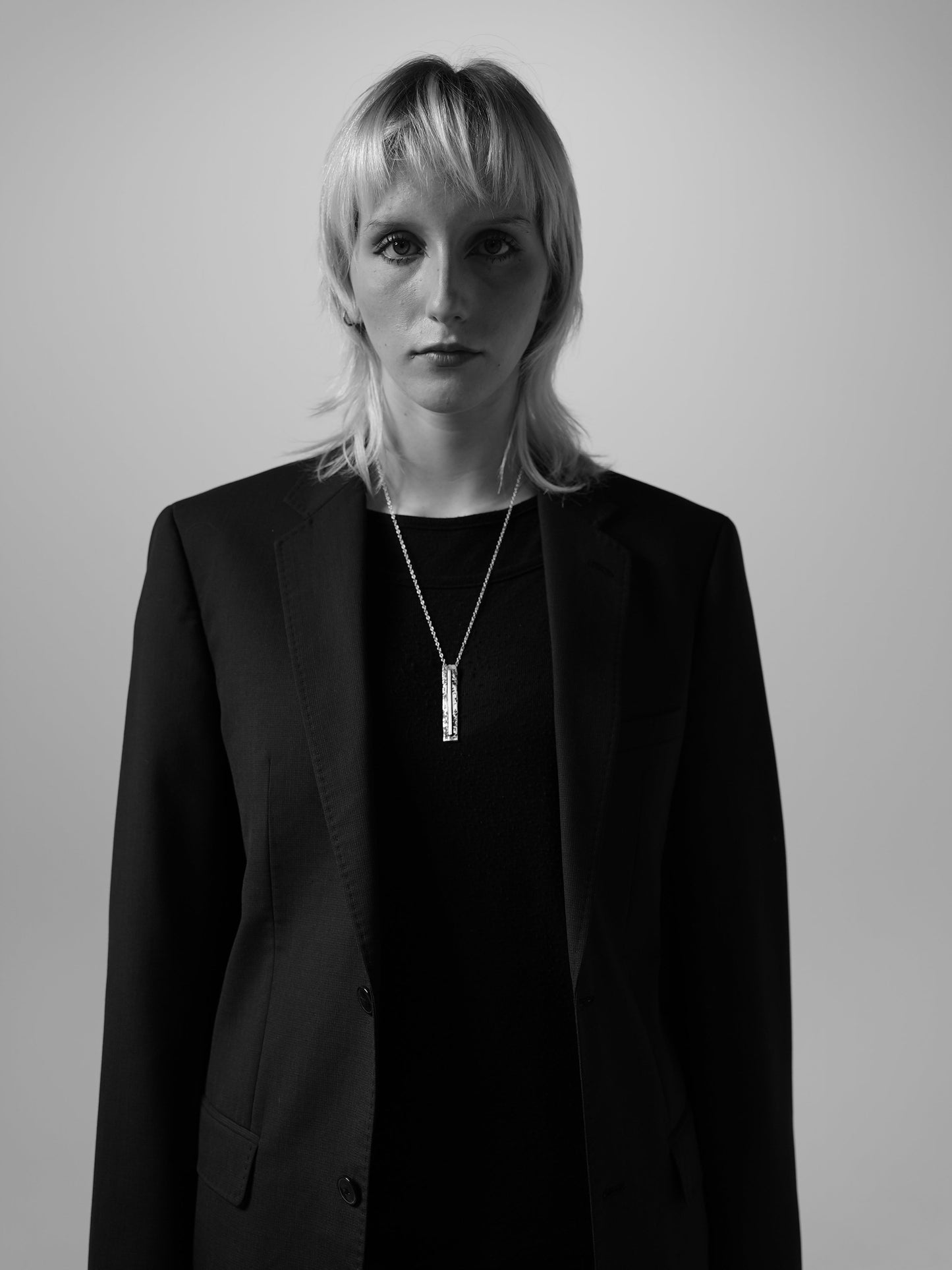 Sculptural silver necklace with rough finish, avant-garde aesthetic. Worn by female model.