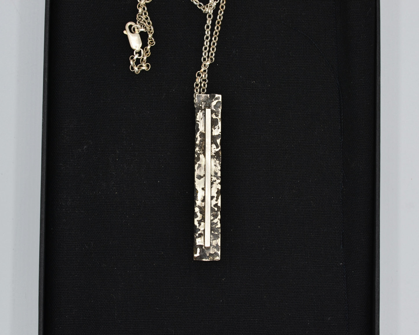 Sculptural silver necklace with rough finish, avant-garde aesthetic
