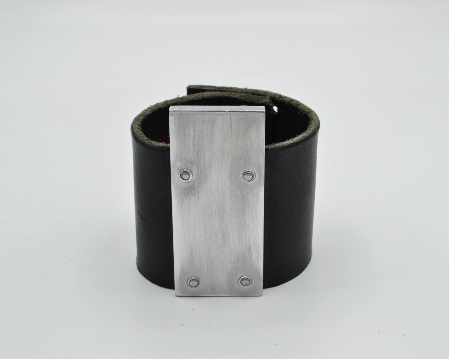 avantgarde, brutalist leather bracelet with aluminum plate mounted on top.