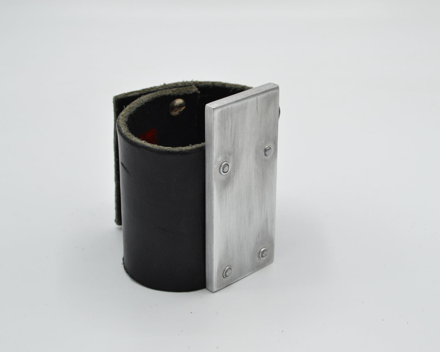 avantgarde, brutalist leather bracelet with aluminum plate mounted on top.