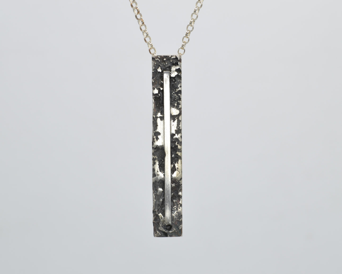 Sculptural silver necklace with rough finish, avant-garde aesthetic