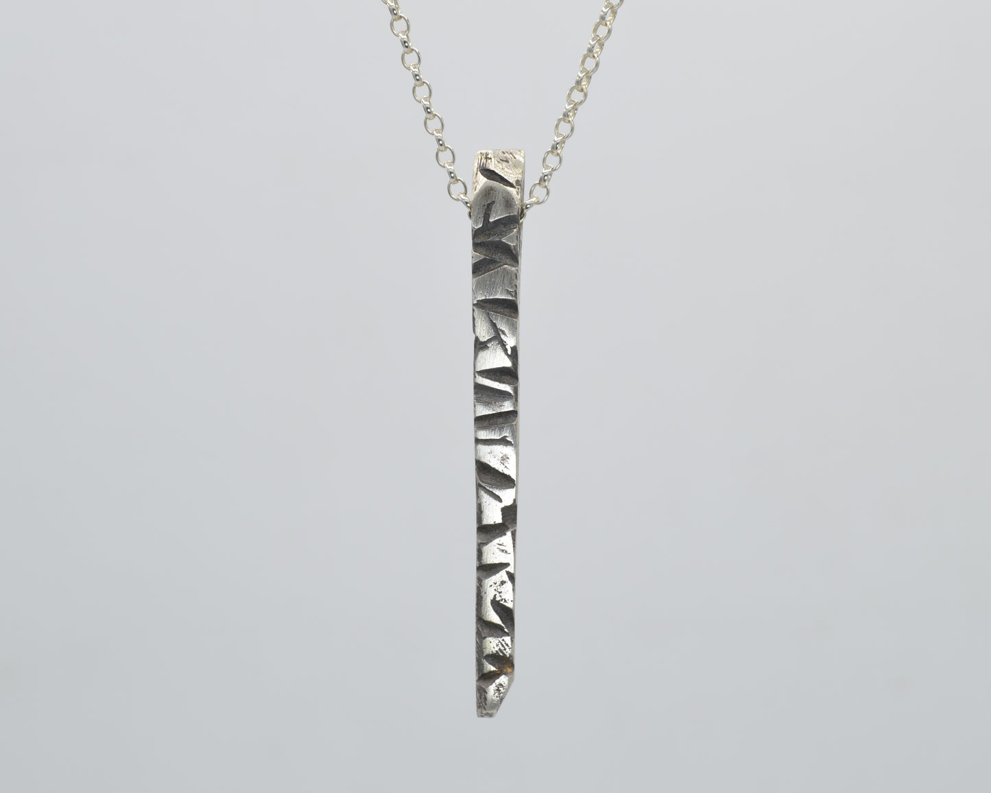 Silver pendant with textured finish, crafted with sand casting method
