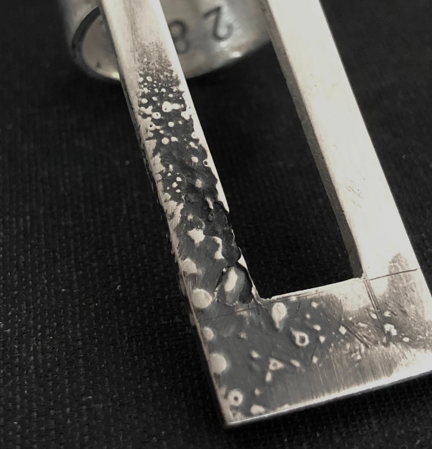 close up of sculptural silver ring with melted, oxiized surface. Handmade jewelry by 2819.