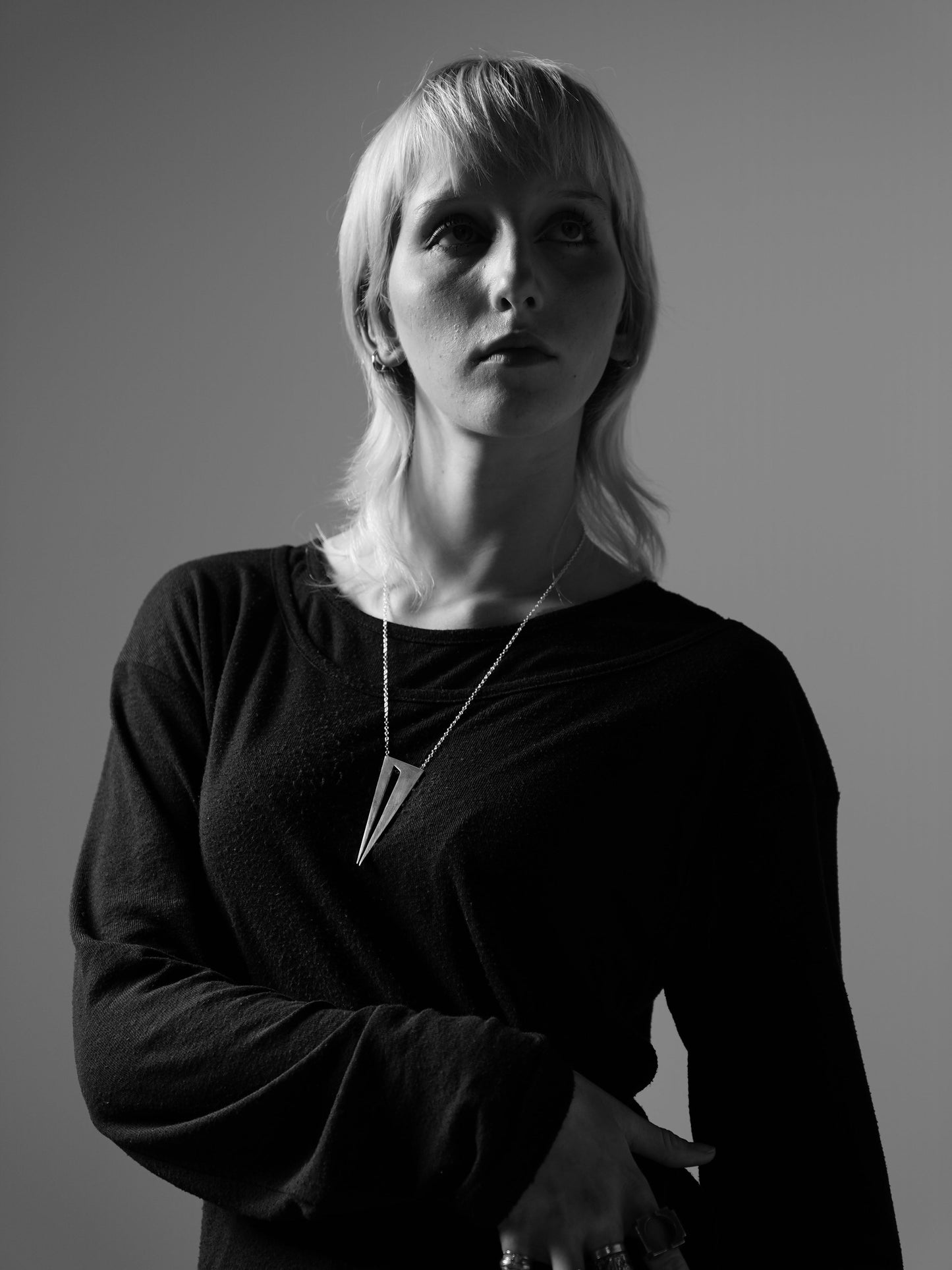 Bold pendant in 950 silver, handmade with a dark, mysterious aesthetic. Worn by female model.