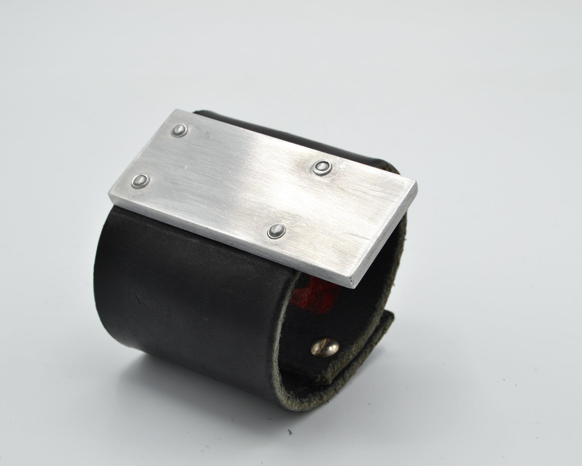 avantgarde, brutalist leather bracelet with aluminum plate mounted on top. 