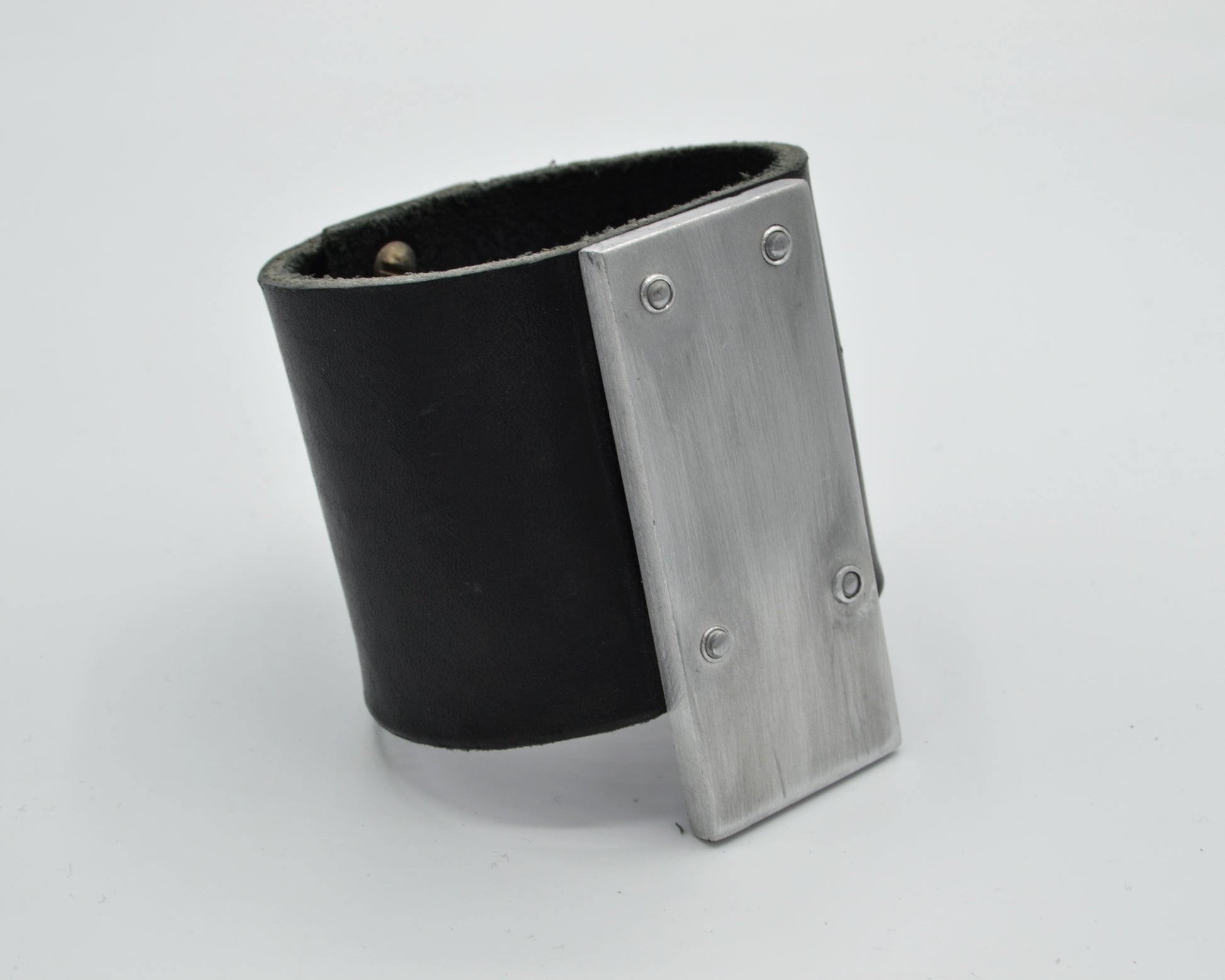 avantgarde, brutalist leather bracelet with aluminum plate mounted on top. 