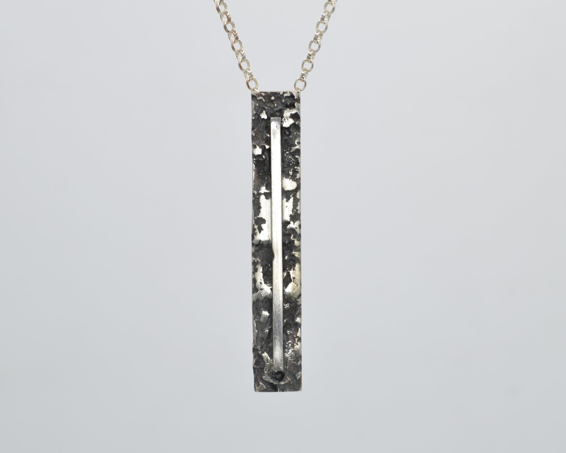 Sculptural silver necklace with rough finish, avant-garde aesthetic